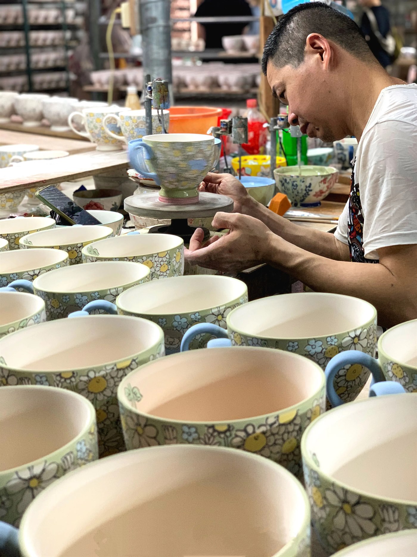 YONGXI craftsman checking ceramic cup finishing detail